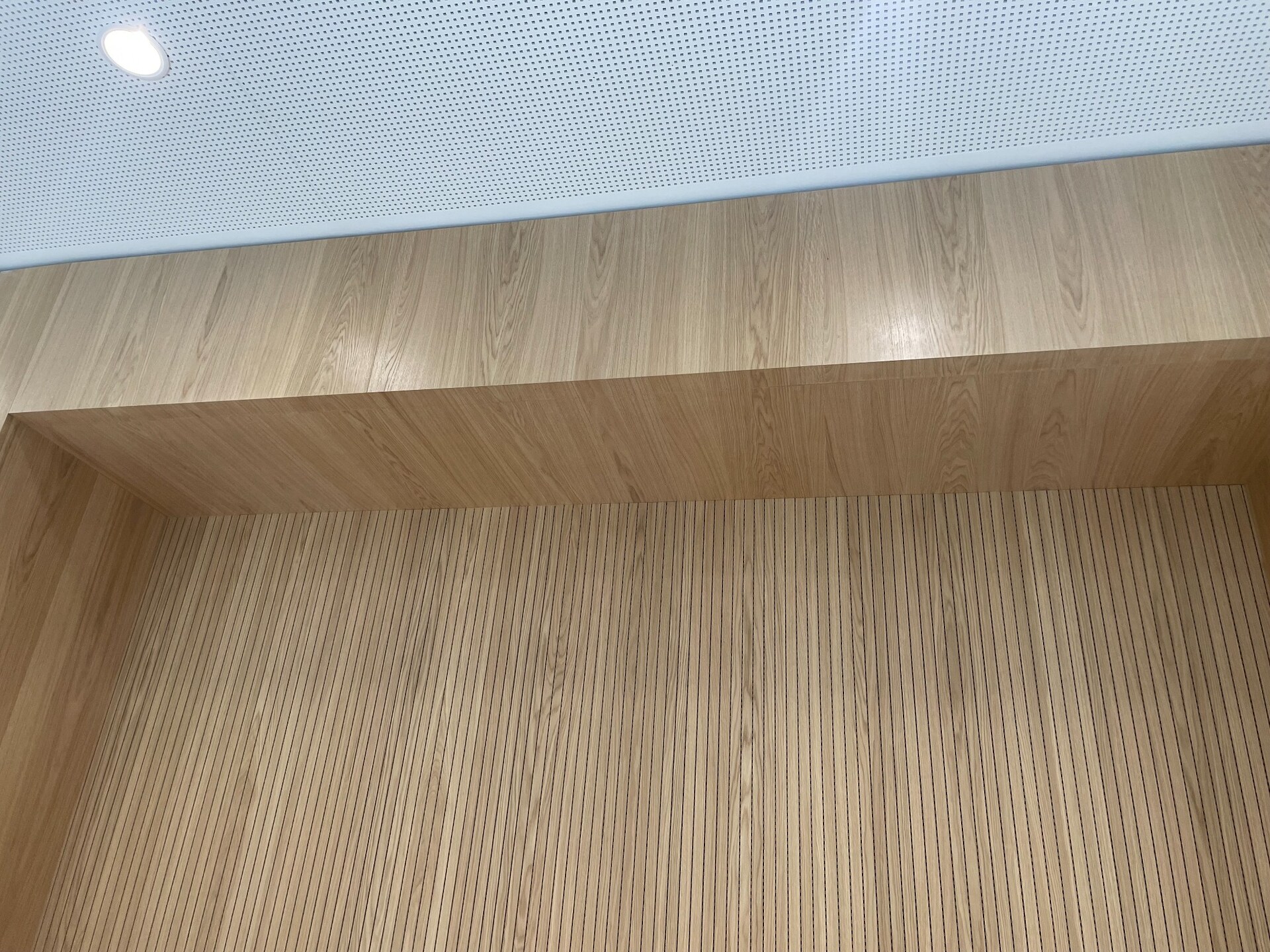 Durchgehende Furnierabwicklung aus Eiche an Wand und Decke